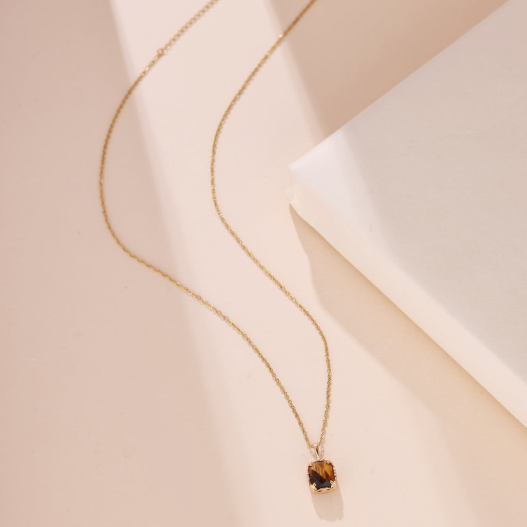 Collier en argent plaqué or avec une pierre œil de tigre rectangulaire facetée et une chaîne délicate.