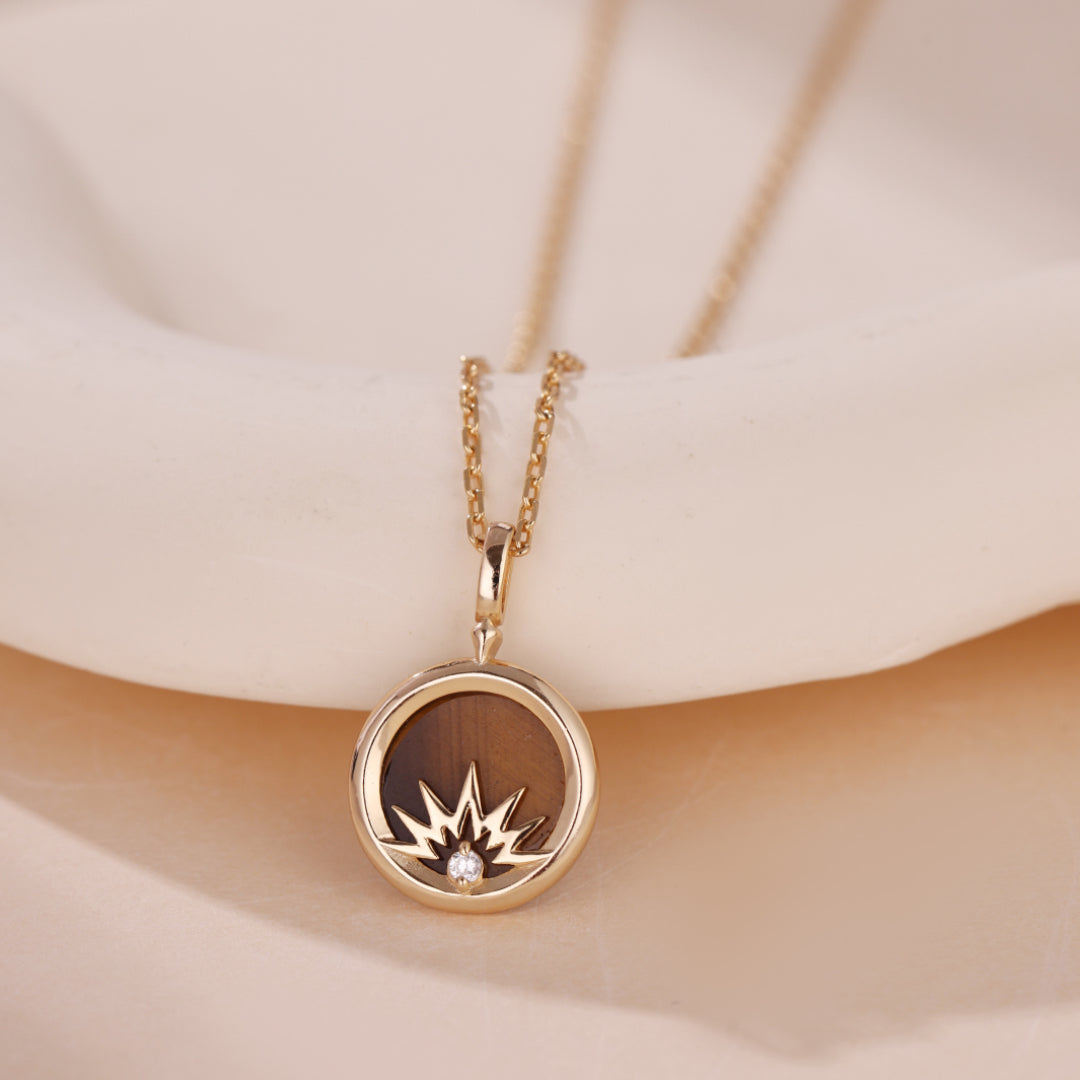 Collier "Lumière Divine" avec un pendentif rond en argent plaqué or, intégrant une pierre œil de tigre et une étoile sertie d'un petit zircon brillant.