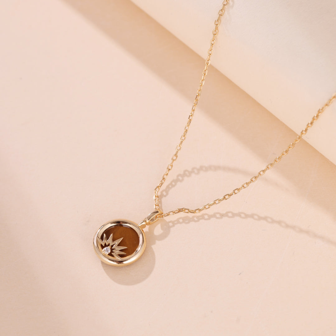 Collier en argent plaqué or avec pendentif œil de tigre rond, serti d'une étoile stylisée et d'un zirconium.