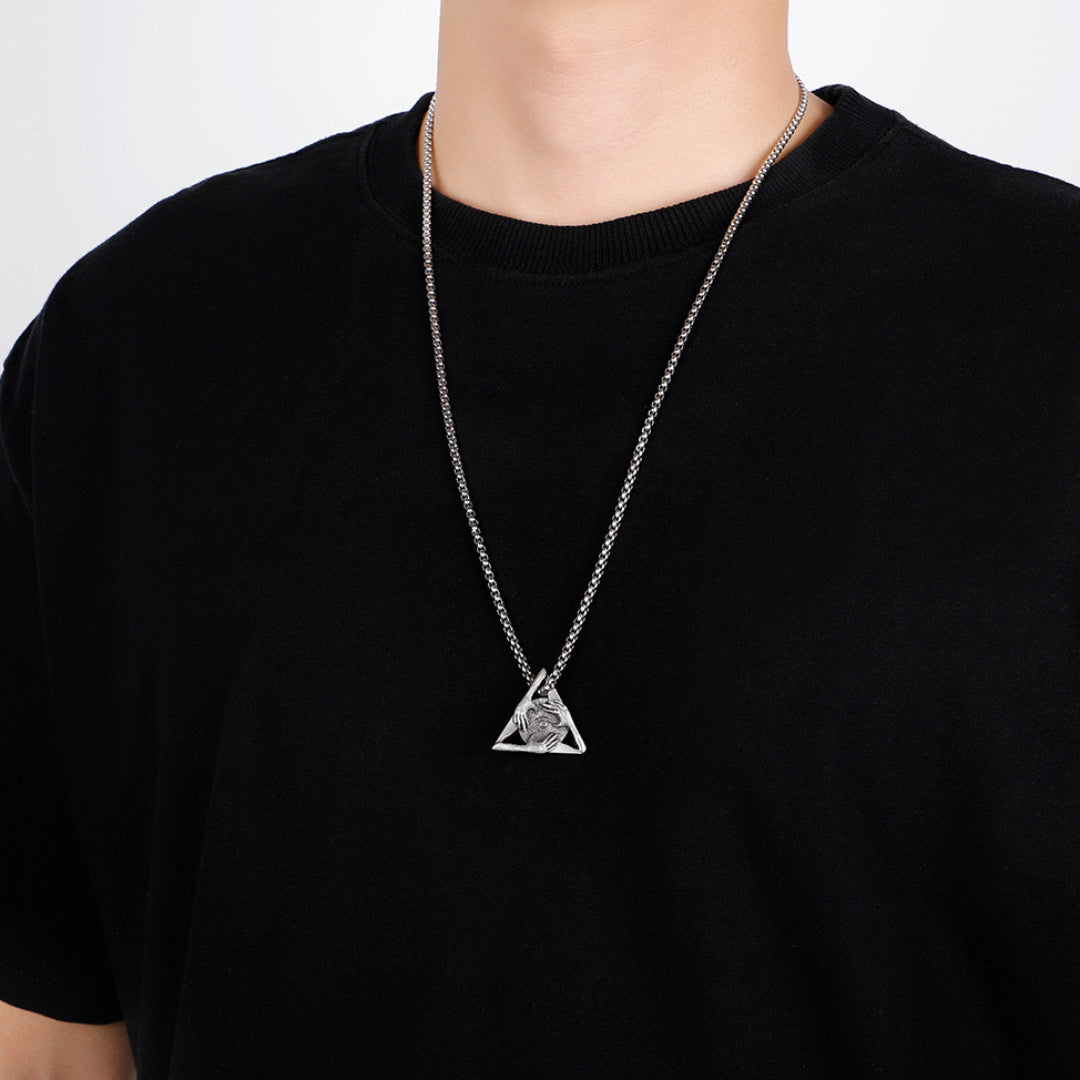 Homme portant un collier avec un pendentif triangle argenté orné d'un symbole complexe