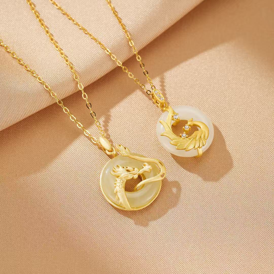 Deux colliers en argent plaqué or avec pendentifs ronds en jade, l'un orné d'un dragon doré et l'autre d'un phénix doré incrusté de zircons.