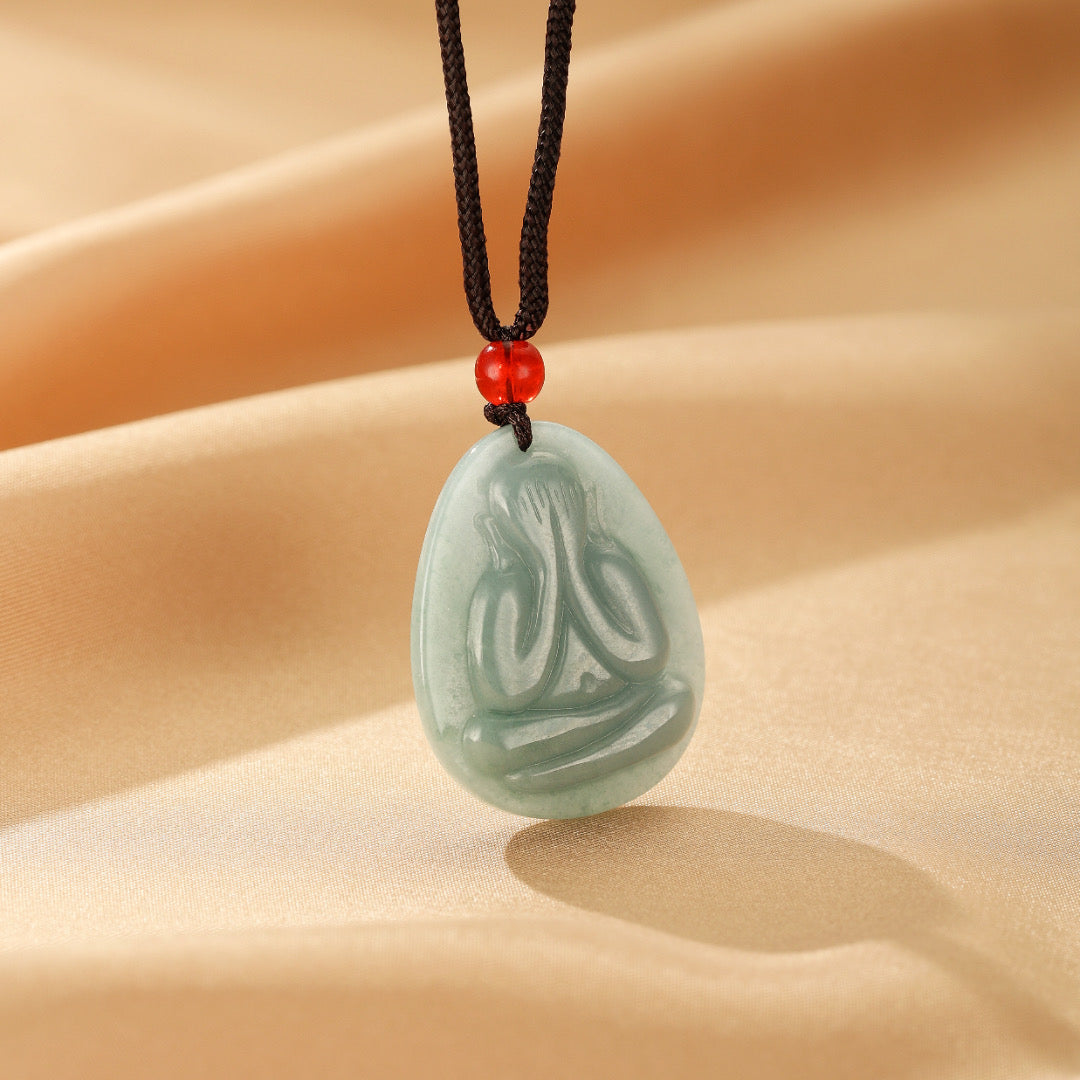 Collier pendentif en jadéite bleue Regard Intérieur gravé d'une silhouette méditative, monté sur cordon noir avec perle rouge, bijou artisanal en pierre naturelle.