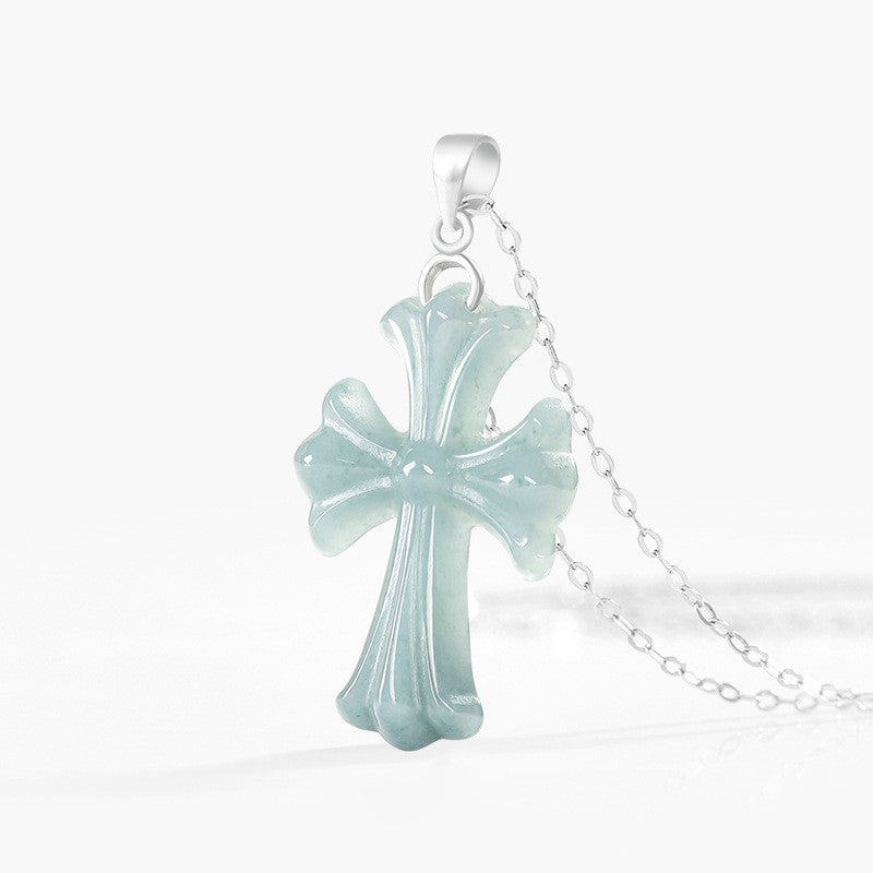 Collier Croix Sérénité avec pendentif en jadéite vert pâle sculpté et chaîne fine en argent sterling sur fond blanc.