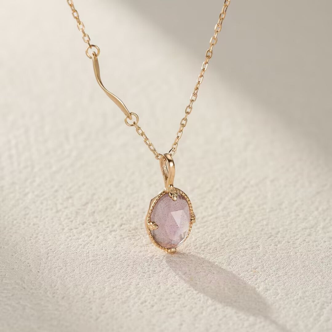 Collier plaqué or avec pendentif ovale en pierre de lune rose facettée, chaîne délicate.