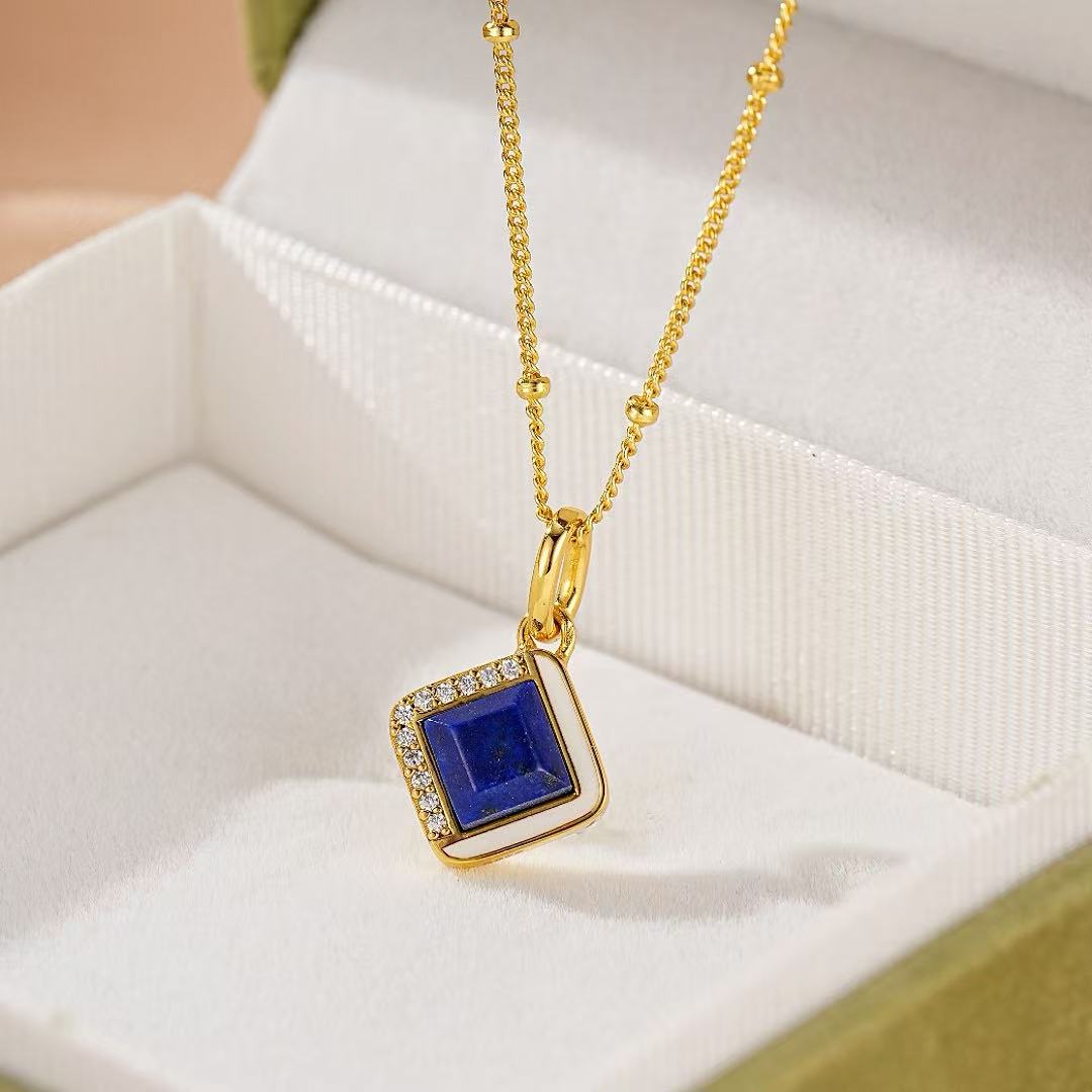 Collier Aura Royale en argent plaqué or avec un pendentif carré bleu lapis-lazuli serti de diamants blancs et entouré d'émail blanc.