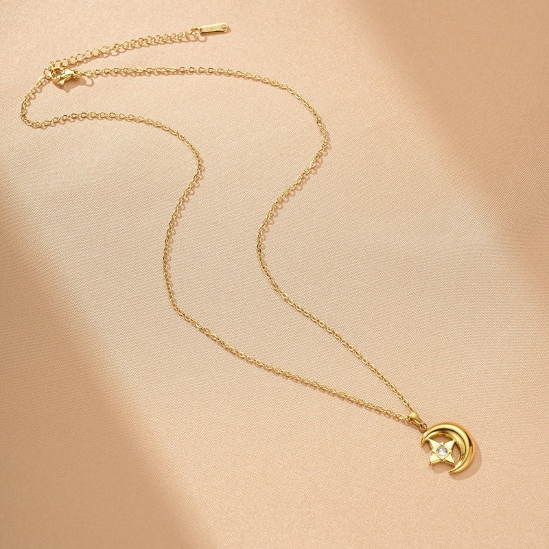 Collier en or jaune avec un pendentif en forme de croissant de lune orné d'une étoile sertie d'un petit diamant.