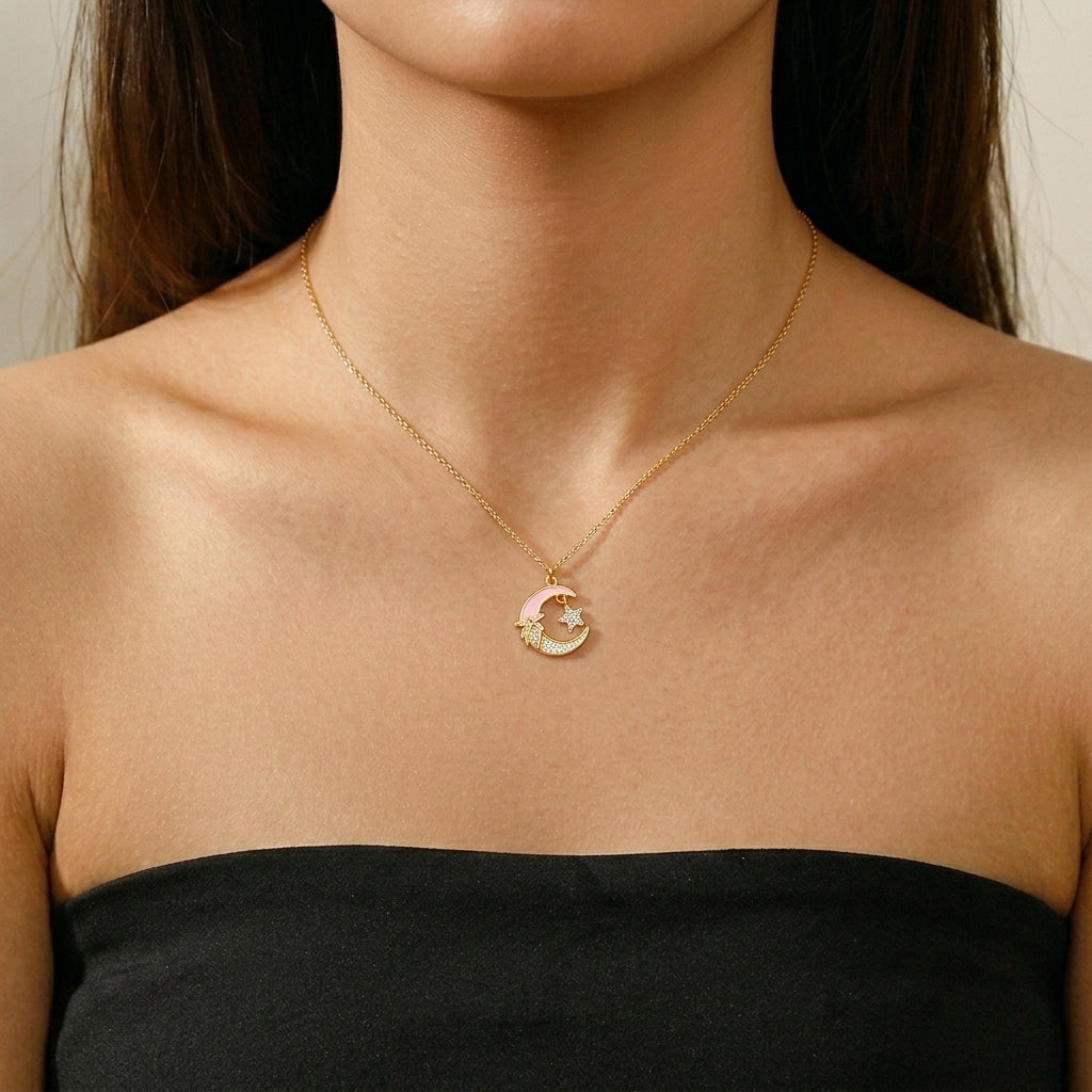 Collier plaqué or avec un pendentif en forme de croissant de lune rose orné d'une étoile scintillante et de petits zircons cubiques.