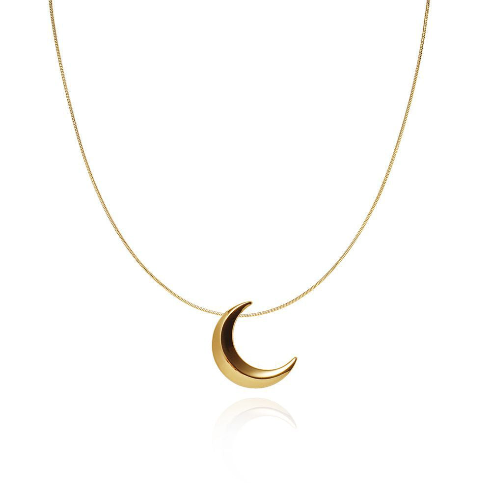 Collier en or avec un pendentif en forme de croissant de lune sur une chaîne fine, arrière-plan blanche.
