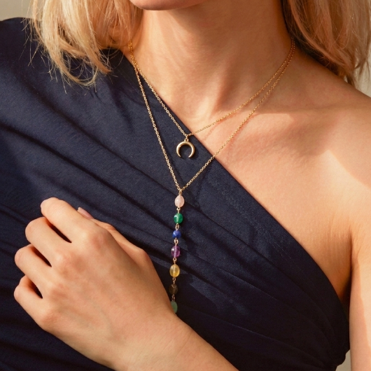 Collier double chaîne plaqué or avec un pendentif croissant de lune et une cascade de pierres naturelles multicolores.