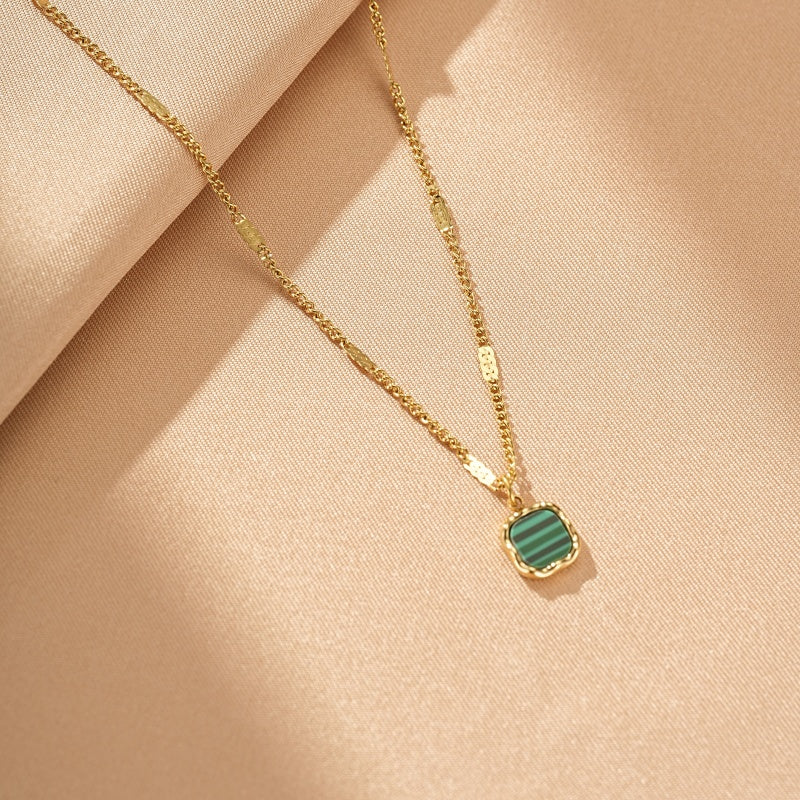 Collier plaqué or avec un pendentif carré en malachite verte aux rayures distinctives.