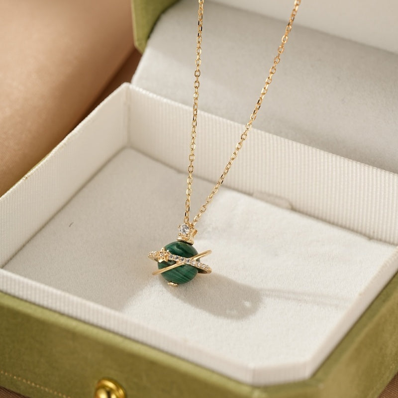 Collier Malachite Sphère Céleste en argent plaqué or, avec une petite pierre scintillante au sommet et un anneau orné de zircons autour de la sphère verte en malachite.
