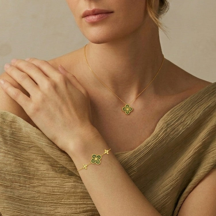 Ensemble de bijoux plaqués or composé d'un collier et d'un bracelet ornés de motifs trèfle sertis de malachite verte.