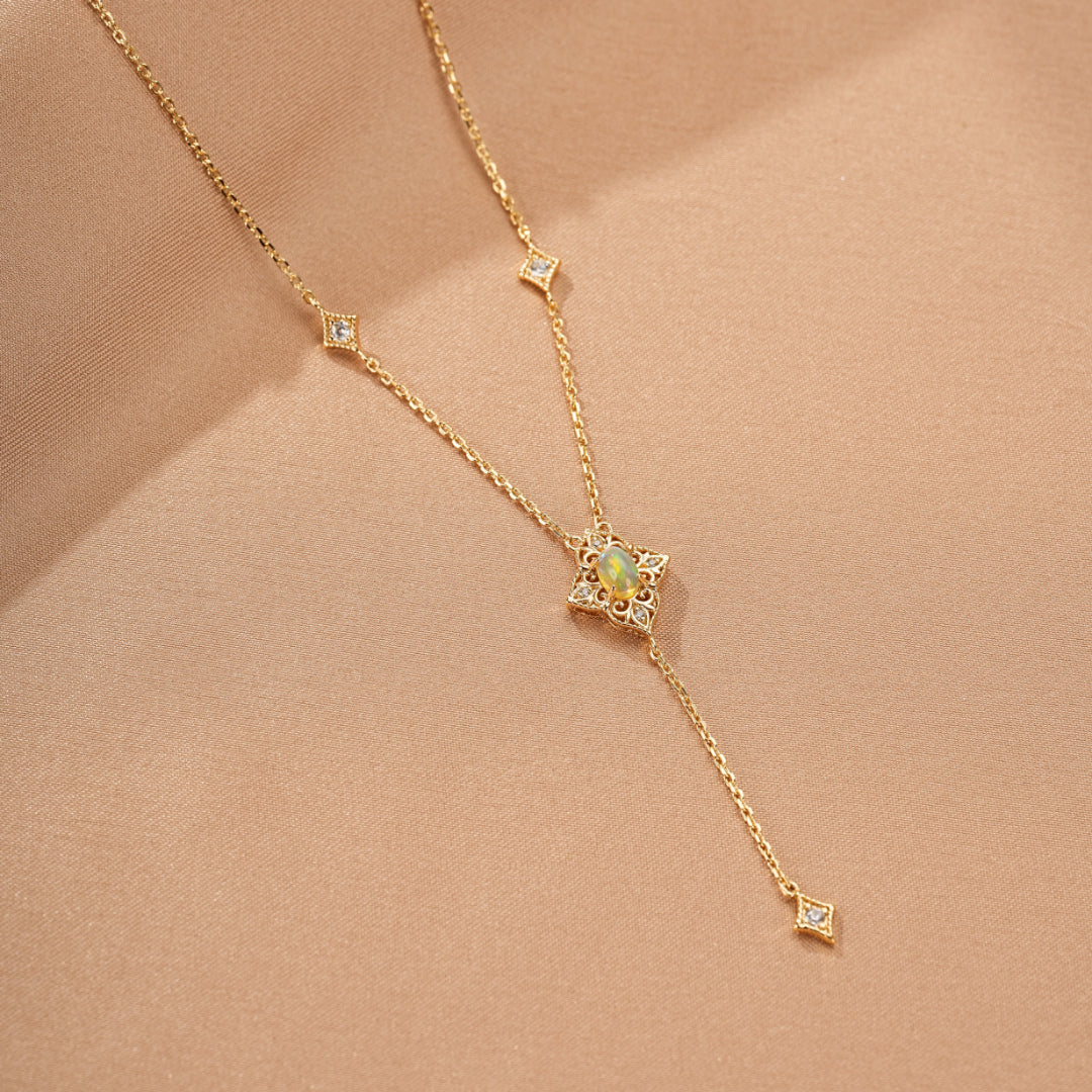 Collier plaqué or 9K avec pendentif étoile orné d'une opale et de petits diamants, chaîne délicate avec des détails géométriques.