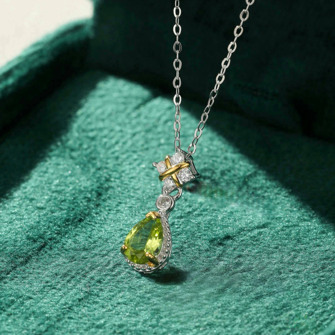 Collier en argent avec pendentif en forme de goutte de péridot vert, serti de petites pierres blanches et d'une touche d'or