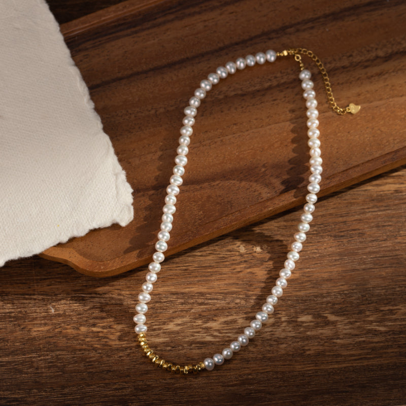 Collier de perles fines et de petites billes dorées, monté sur une chaîne plaquée or.