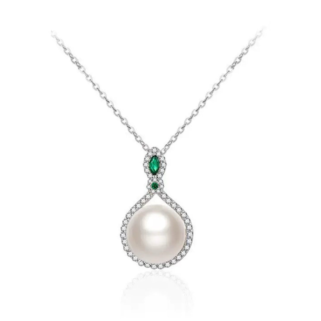 Collier en argent 925 avec une perle blanche centrale, entourée de zircons et orné de deux émeraudes vertes en forme de goutte.