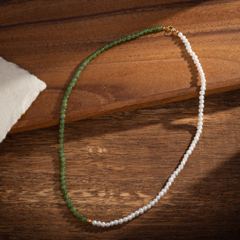 Collier bicolore avec perles blanches et pierres de jade vertes, monté sur une chaîne en argent plaqué or.