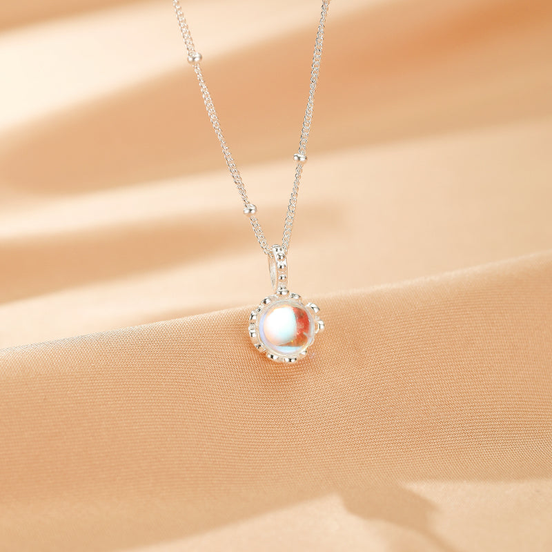 Collier "Éclat de Nuit" en Argent 925 orné d'une pierre de lune aux reflets iridescents, suspendu à une chaîne délicate parsemée de petites perles.