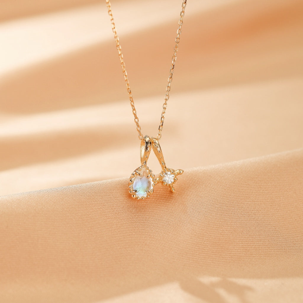 Pendentif "Rêve Étoilé" en argent plaqué or 14 carats orné d'une pierre de lune nacrée en forme de goutte et d'une moissanite scintillante.