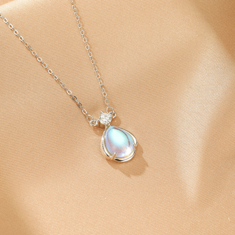 Collier "Larme Céleste" en argent avec un pendentif en pierre de lune bleutée en forme de larme et une petite zircone scintillante.