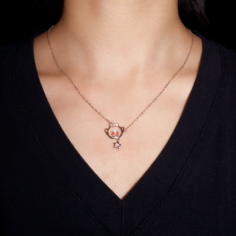 Collier Rêve Sidéral en argent avec un pendentif original en forme de petite théière renfermant une pierre de lune et orné d'une étoile violette.