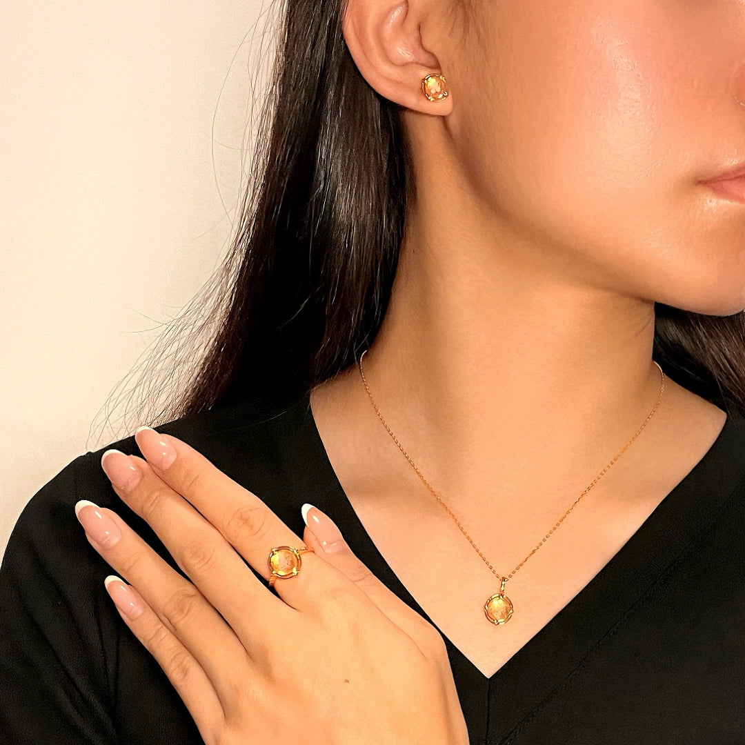 Collier en quartz rose et argent plaqué or 10K, mettant en valeur une femme portant le collier, une bague et des clous d'oreilles assortis.