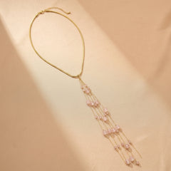 Collier élégant Cascade Lumineuse avec perles de quartz rose naturel suspendues sur une chaîne dorée fine.
