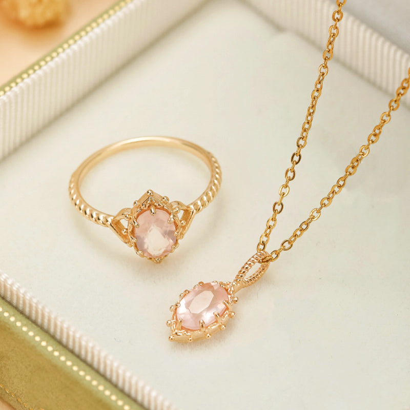 Ensemble de bijoux "Floraison" en argent plaqué or comprenant une bague et un collier ornés de quartz rose ovale.