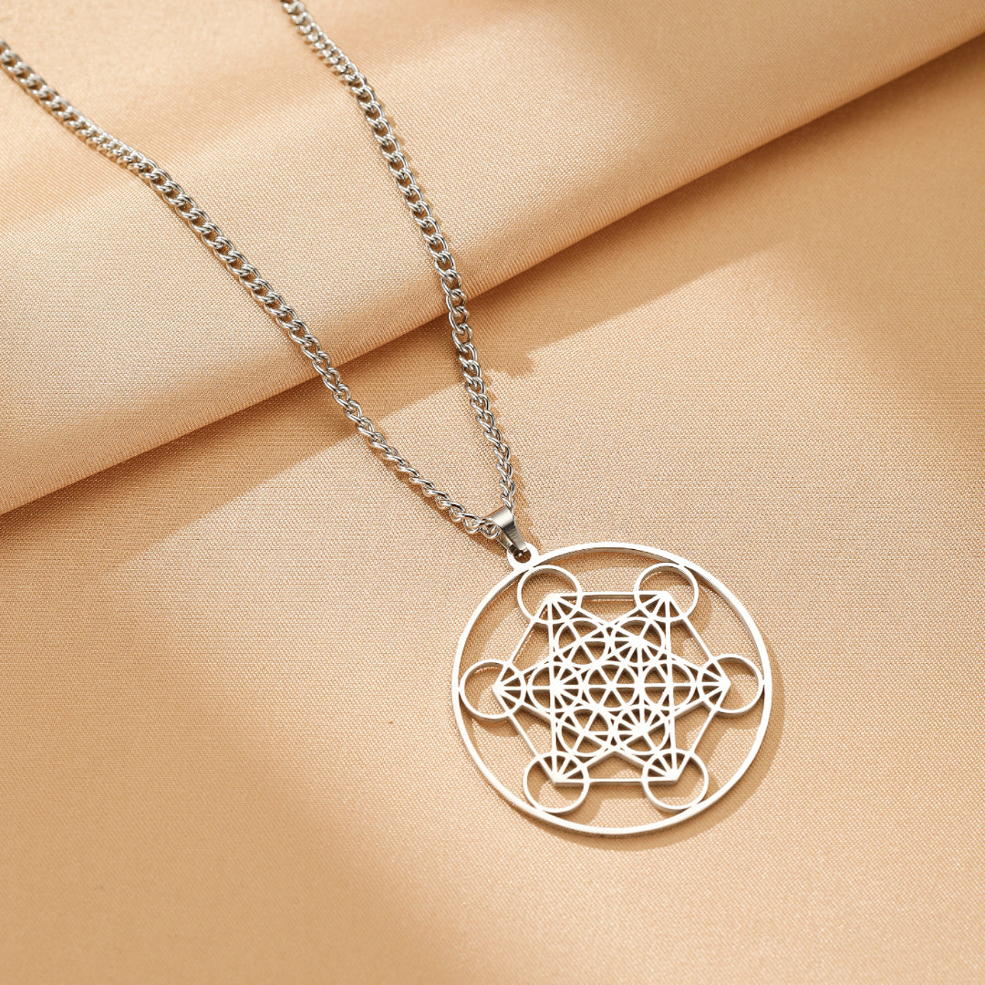 Collier avec pendentif rond en acier inoxydable orné d'une géométrie sacrée complexe de type Sri Yantra, suspendu à une chaîne argentée.