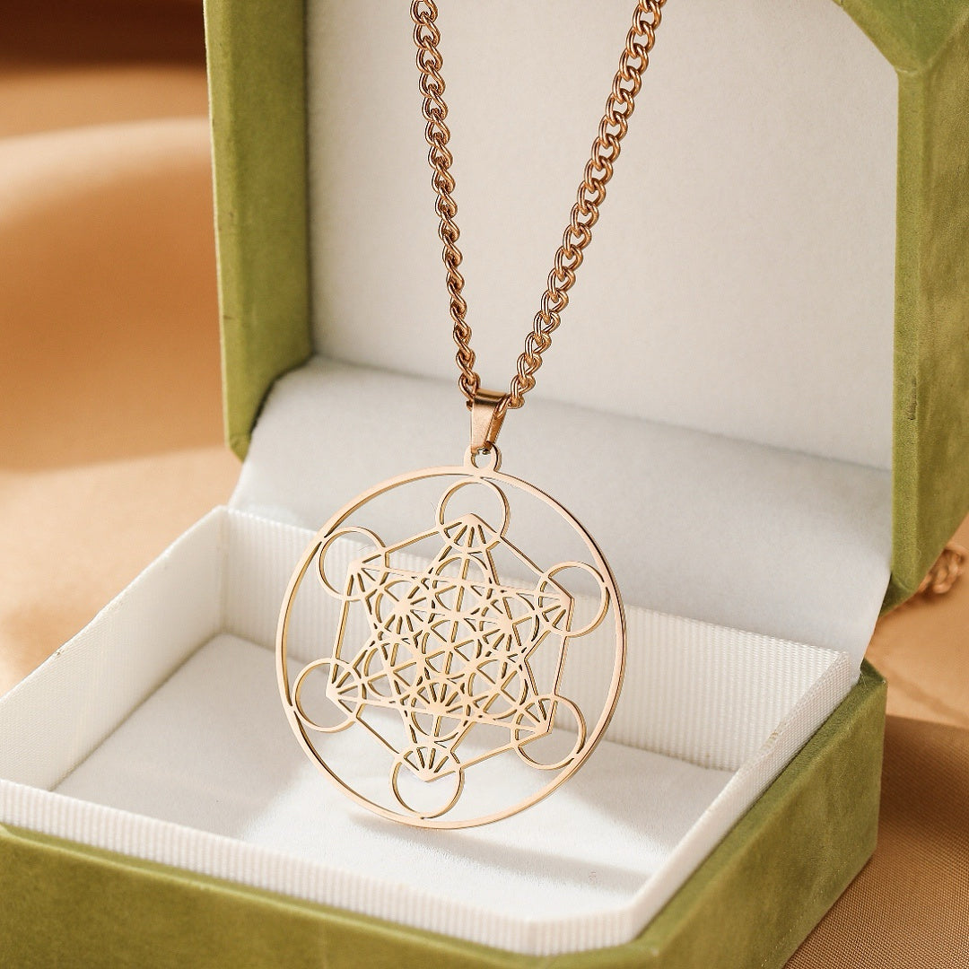 Collier pendentif doré avec le motif de géométrie sacrée Sri Yantra, présenté dans un écrin vert.