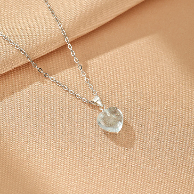 Collier Topaze Cœur Céleste en argent avec pendentif en forme de cœur en pierre transparente sur une chaîne fine en argent.