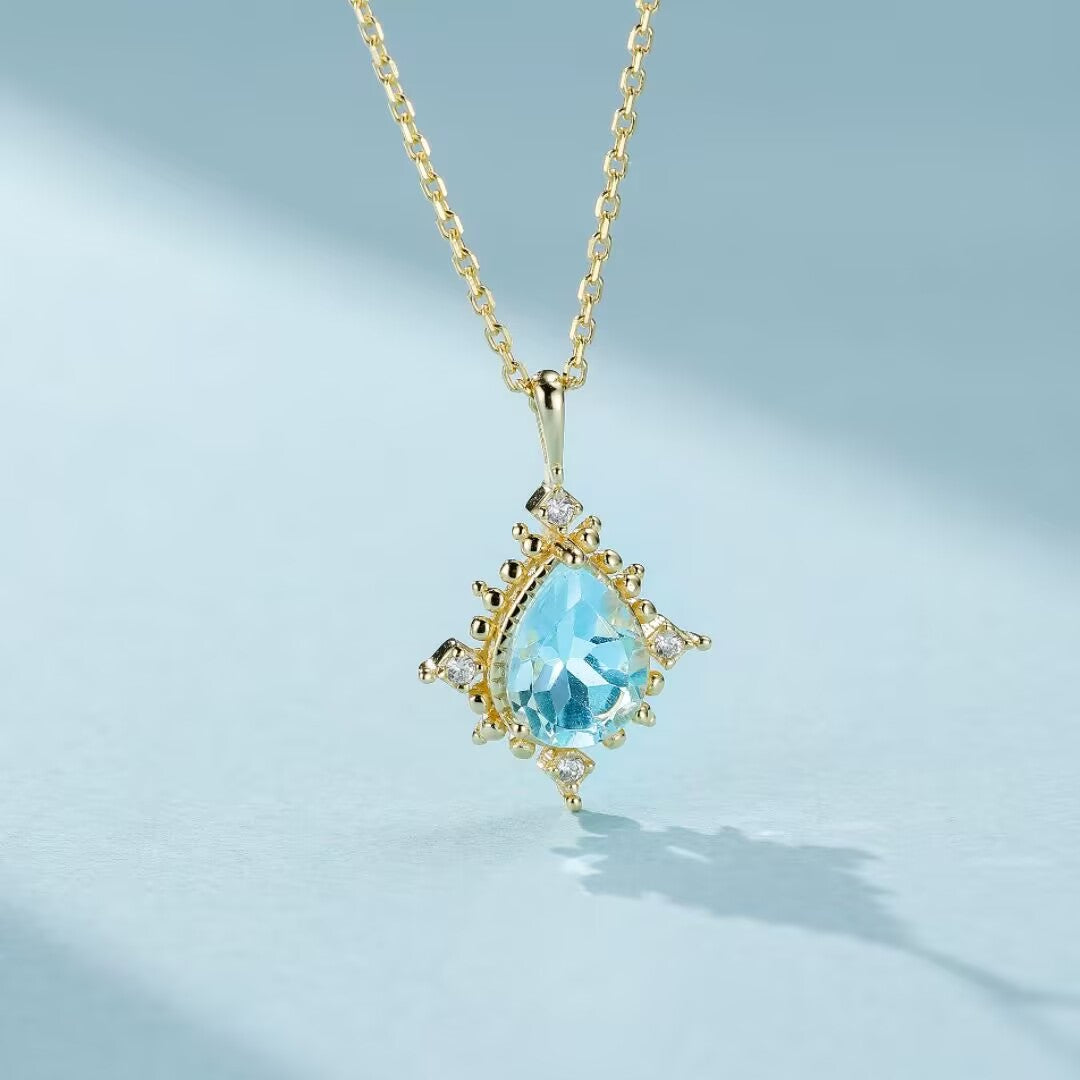 Collier "Lumière d’Apollon" en argent 925 avec une topaze bleue en forme de goutte et de petits diamants incrustés.
