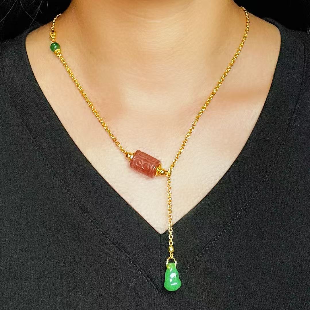 Collier en or jaune avec pendentif en tourmaline sculptée rose et une petite breloque en jade vert en forme de gourde.
