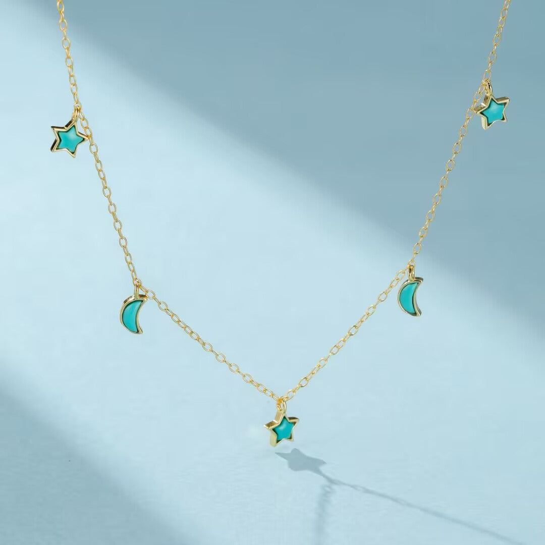 Collier en argent plaqué or avec pendentifs en forme d'étoile et de lune incrustés de turquoise.