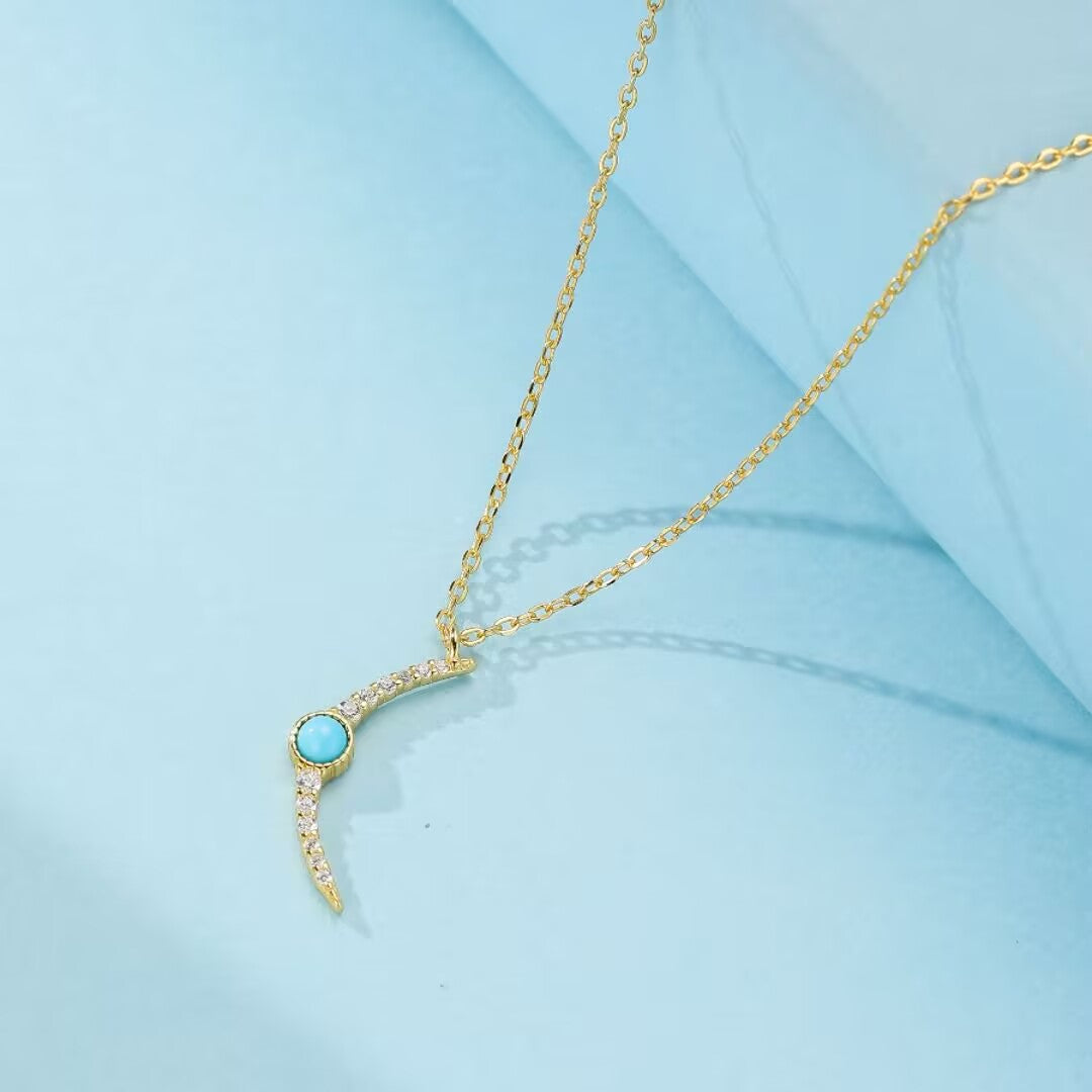 Collier en argent 925 avec pendentif en forme de croissant de lune orné d'une turquoise centrale et de zirconium cubiques scintillants.