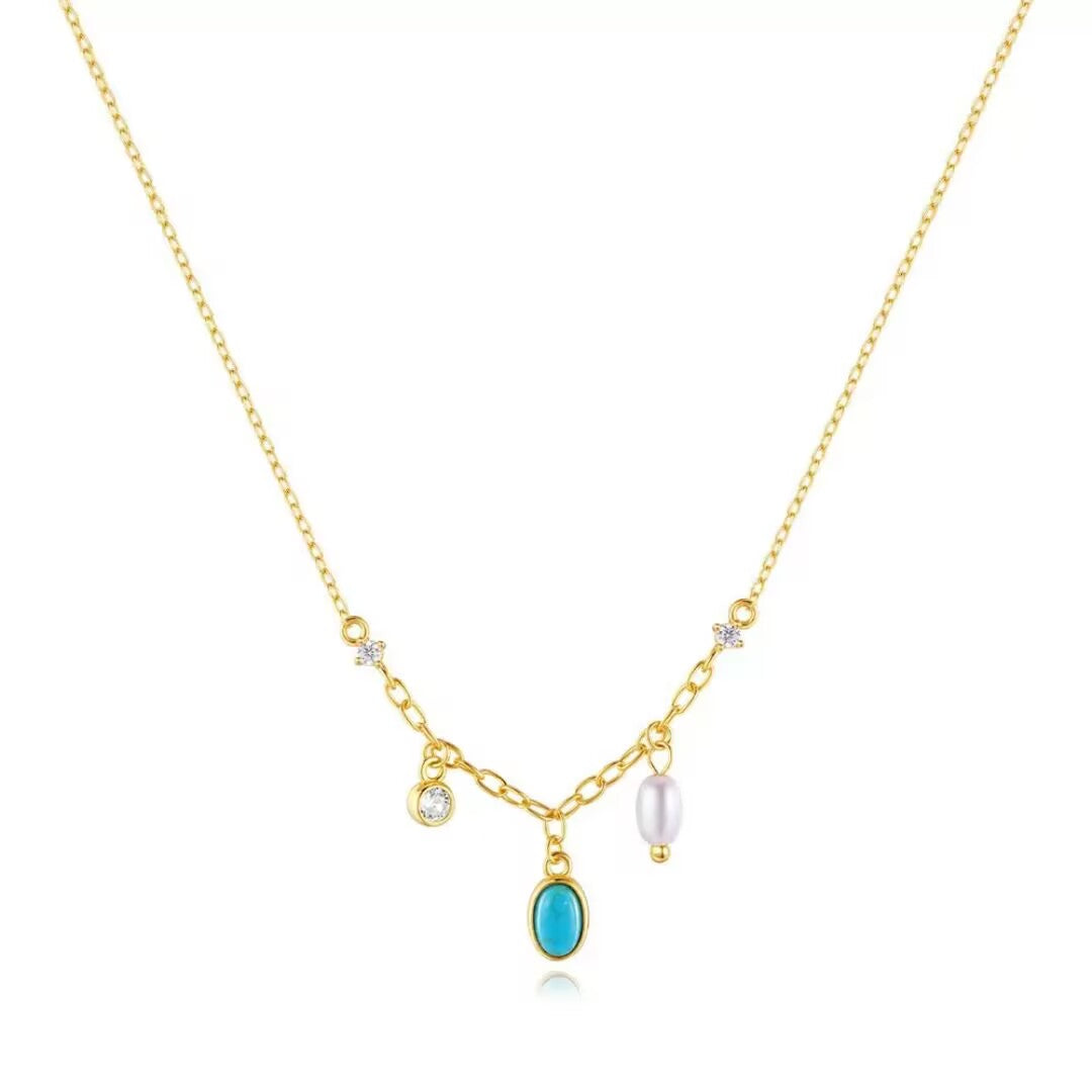 Collier en argent plaqué or avec une turquoise ovale, une perle rose pâle et des zircons cubiques sertis sur une chaîne délicate.