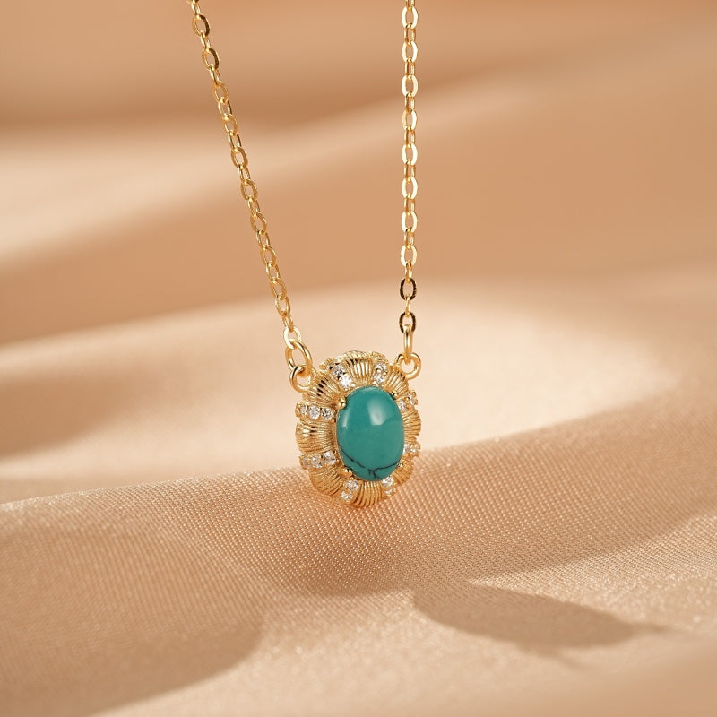 Collier en argent plaqué or avec une turquoise ovale et des petites pierres scintillantes, chaîne fine.