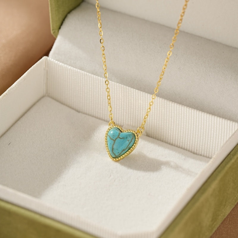 Collier en argent plaqué or avec un pendentif en forme de cœur de turquoise, présenté dans une boîte cadeau verte.