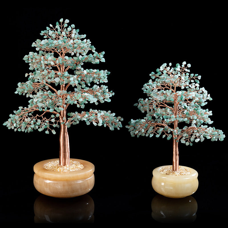 Deux arbres de vie décoratifs, l'un grand et l'autre plus petit, fabriqués avec des pierres d'aventurine verte et des fils de cuivre, reposant sur des pots en onyx blanc laiteux. L'arrière-plan est noir.