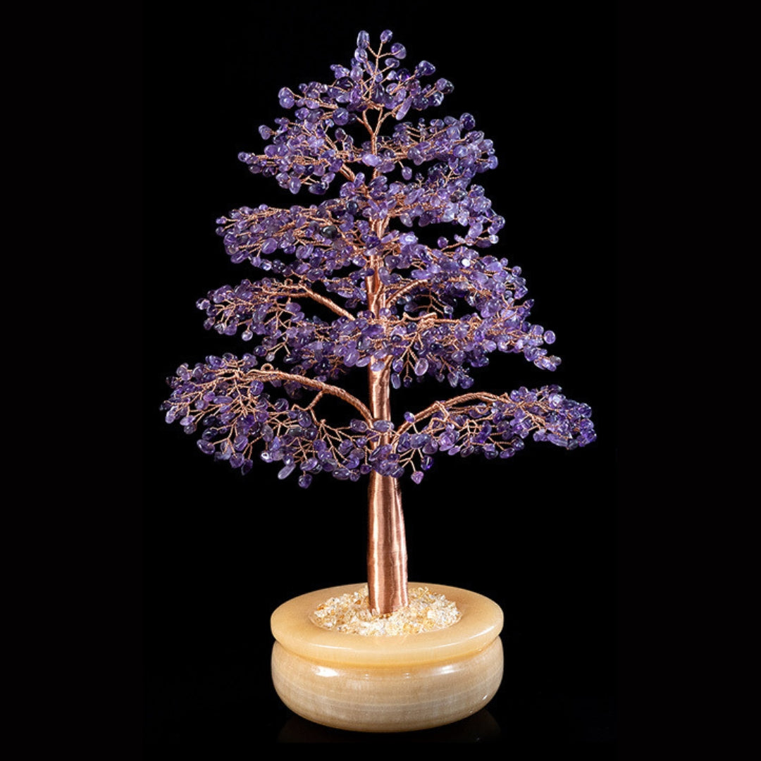 Grand arbre de vie décoratif avec des feuilles en améthyste violette et un tronc en cuivre, posé sur un pot en onyx clair rempli de gravier.