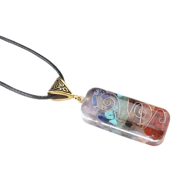 Pendentif rectangulaire 7 chakras en pierres naturelles multicolores, incrusté d'un fil de cuivre torsadé et monté sur un cordon noir, bijou de bien-être et de lithothérapie.