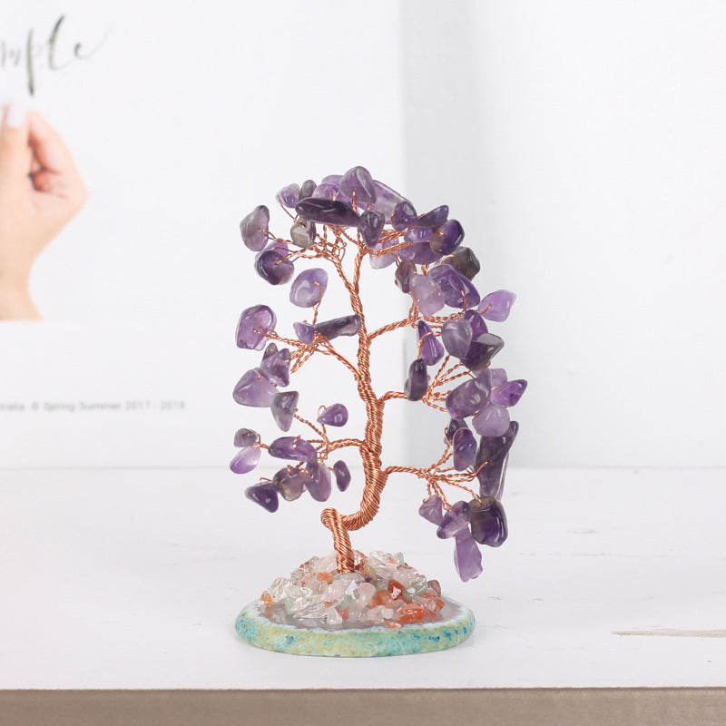 Porte-bonheur Arbre de Vie décoratif en pierres d'améthyste et fil de cuivre sur un socle de pierres mélangées.