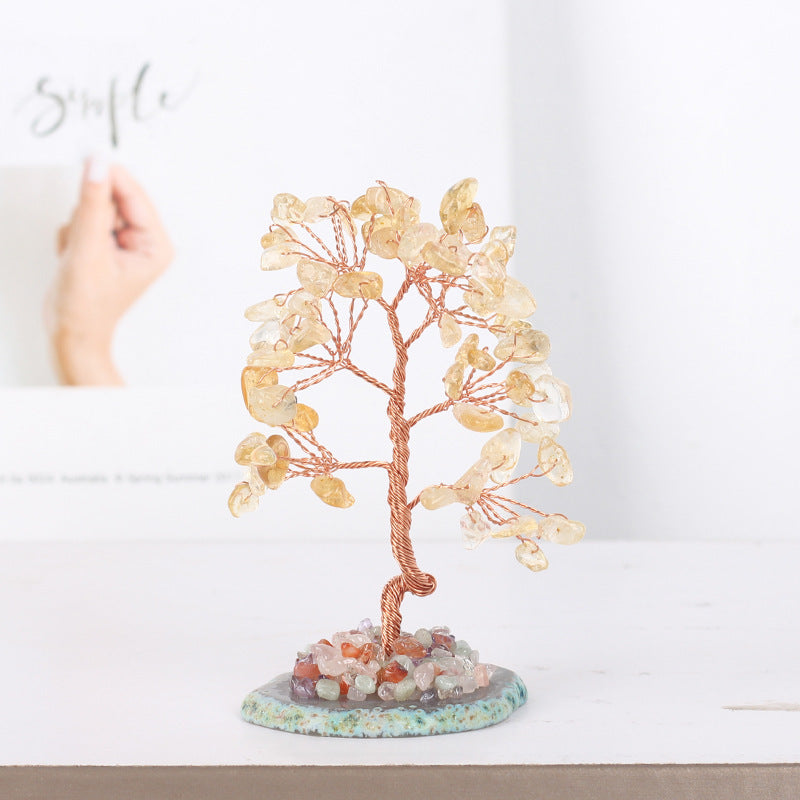 Arbre de vie porte-bonheur fait de pierres jaunes et de cuivre torsadé, posé sur une base de pierres multicolores et de agate
