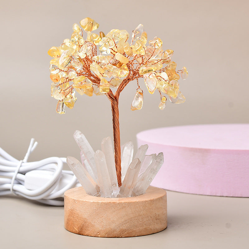 Arbre de vie lumineux en pierres naturelles de citrine et quartz, avec une base en bois et un câble d'alimentation blanc.