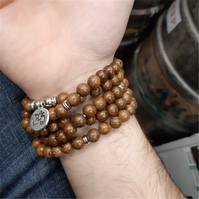 Le sublime mâlâ "Placide" en bois de Wengé porté comme bracelet autour du poignet d'un homme