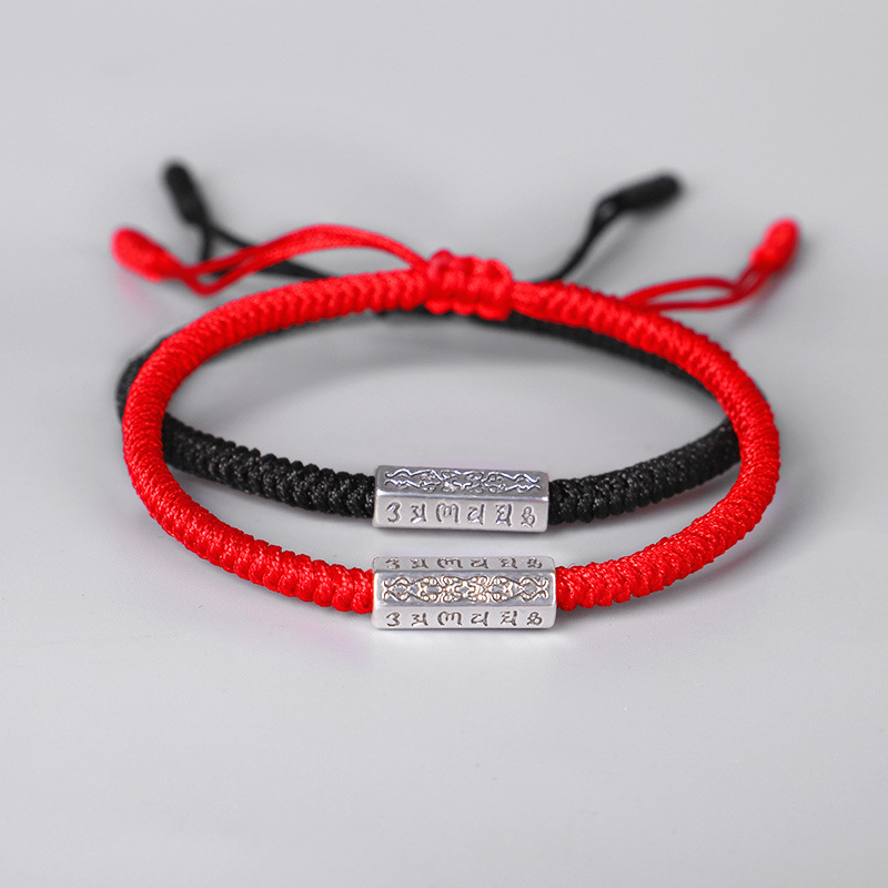 Mantras en bracelet avec du fil rouge en noir et en rouge sur fond blanc