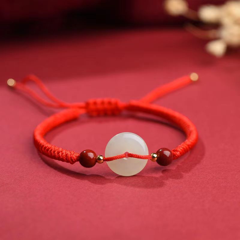 Le bracelet Bonbon en Rouge Vif avec pierre de Jade sur nappe rouge